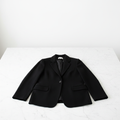 Blazer de cachemira negro sobre mármol blanco