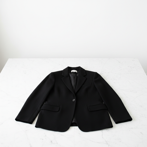 Blazer de cachemira negro sobre mármol blanco