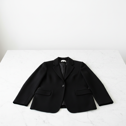 Blazer de cachemira negro sobre mármol blanco